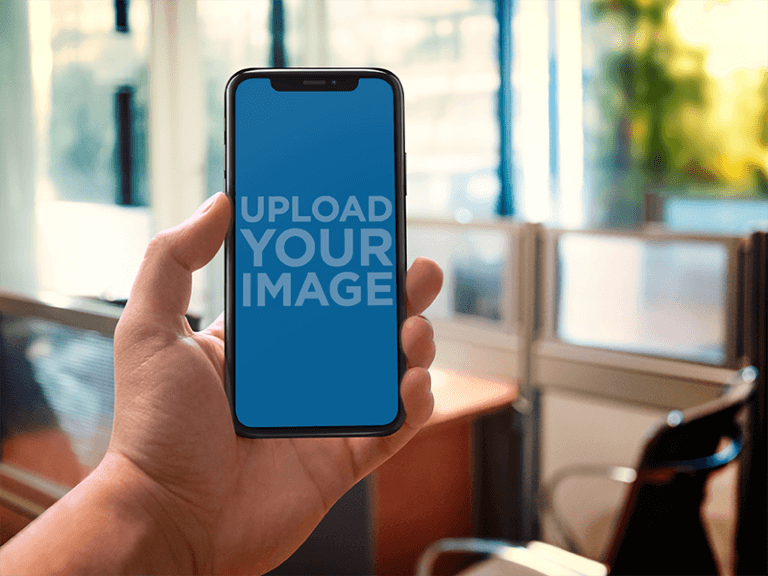 Iphone X Mockup Being Held Against An Office A17678